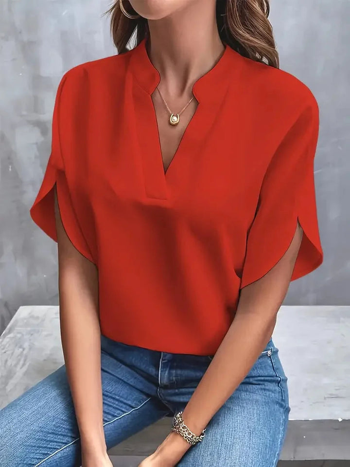 Willa women's red V-neck blouse with flowy short sleeves, paired with jeans.