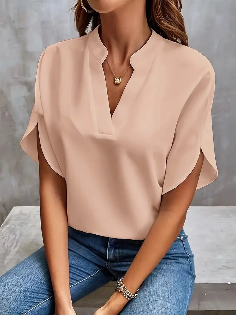 Willa women's blush V-neck blouse with flowy short sleeves, paired with jeans.