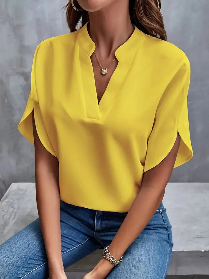 Willa women's soft, flowy yellow V-neck blouse with split short sleeves, paired with jeans.