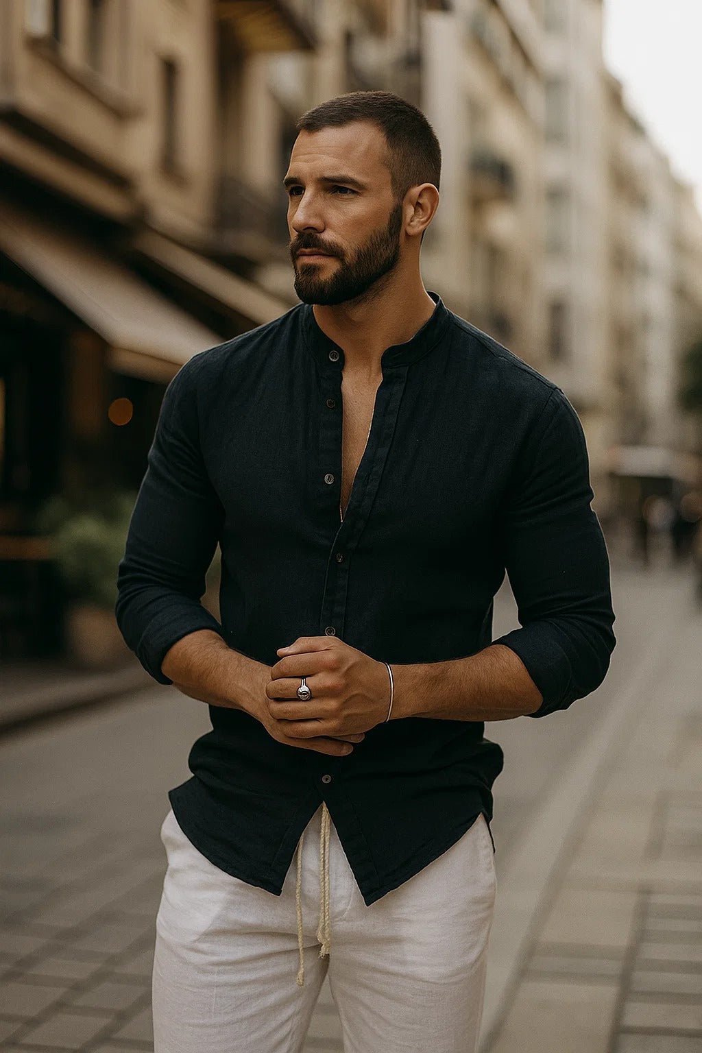 Man in a dark navy Zion band collar button-up shirt with long sleeves, paired with white drawstring pants.