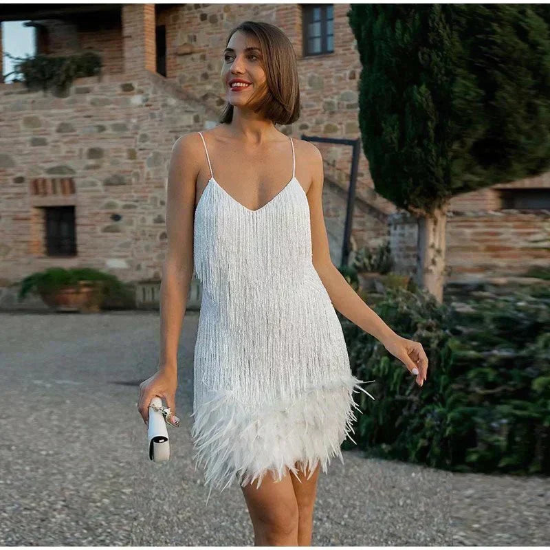 Woman in a white sequin fringe mini dress with a feathered hemline.