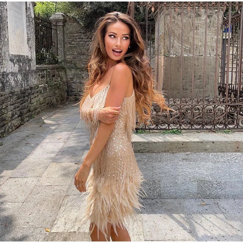 Woman in the Zoe beige sequin mini dress with fringe and feathers.